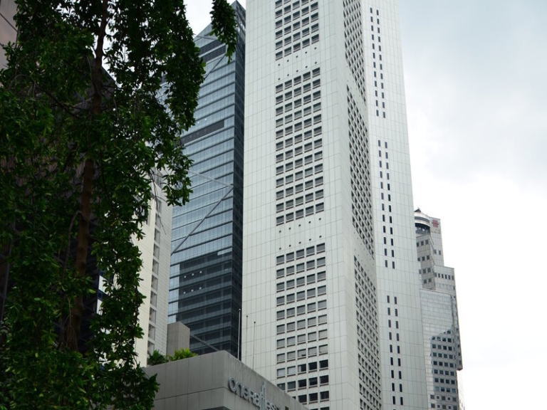 High-rise building with a grid-patterned facade framed by trees