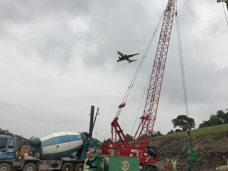 Foreign quantity surveyor in Singapore reviewing plans on a construction site