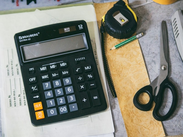 Calculator, paper and office supplies on a desk