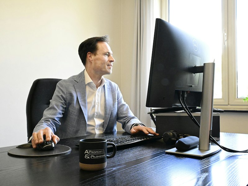 Professional in a suit working at a computer desk, illustrating EP salary by age requirements in Singapore