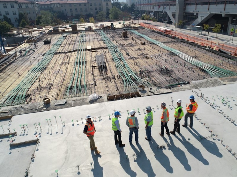Construction workers in hard hats and high-visibility vests standing together on site